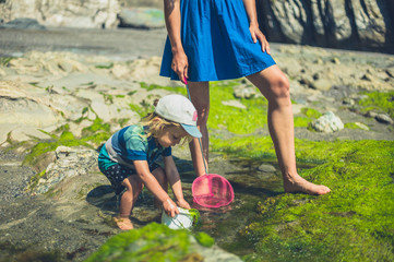 Young mother and her toddler on the beach with a net