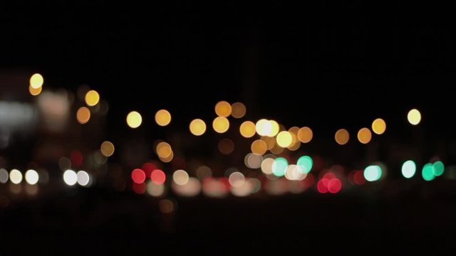 Lights of the night city background. Defocus headlights of moving cars urban traffic. Abstract bright blured colored bokeh.