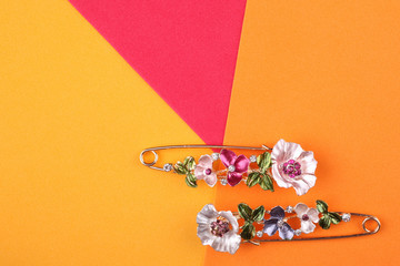 Two beautiful brooches with flowers on an orange background