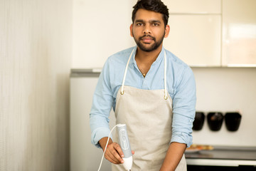 Handsome young man standing in the kitchen at home