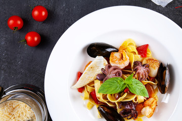 Top view on traditional italian pasta with seafood served on dark background. Flat lay italian cuisine with copy space for design. mediterranean noodle for lunch Dark background