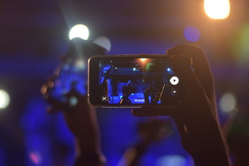 Fototapeta na wymiar A boy making video at concert.