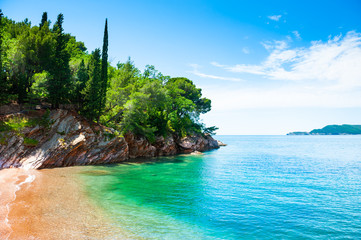 Beautiful beach with turquoise water and cliffs near Budva, Montenegro. Summer seascape, travel and vacation