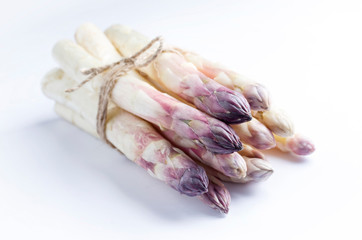 Raw white Asparagus with violet head as bunch on white background with copy space - isolated