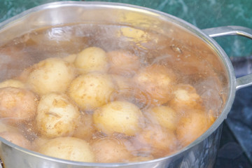 New potatoes boil in their skins in a saucepan