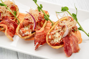 Potato skin with bacon and cheese, tomato sauce