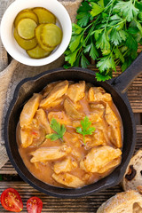 Chicken fricassee with pickles in white sauce with tomatoes