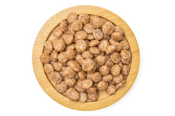 Lot of whole chocolate ball breakfast cereals on bamboo plate flatlay isolated on white background