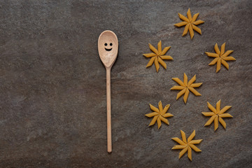 penny pasta pattern, several pasta stacked in a flower, wooden spoon with smile, natural stone surface, space for text