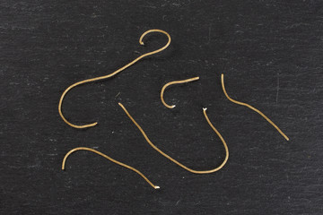 Fototapeta na wymiar Group of five pieces of thin raw pasta noodles flatlay on grey stone