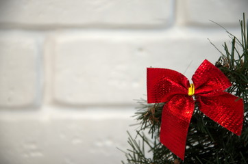Red Christmas bow with a Christmas tree branch on a white background