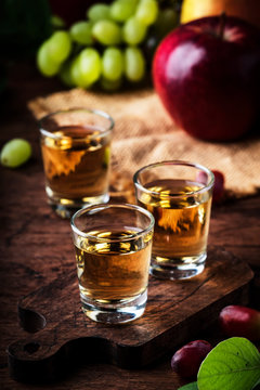 Rakija, raki or rakia - Balkan hard alcoholic drink or brandy from fermented fruits, old wooden table, still life, copy space