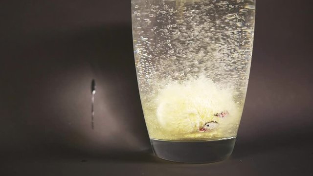Ball form bath salt with interesting pattern drop slow motion in vase of water