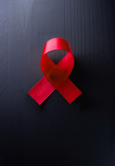 world aids day with red ribbon symbol on dark wood background, 1 desember, Vertical image