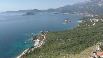 Drone flies above the coastline of the Adriatic sea, southern Montenegro, in a sunny summer day. Water in the sea is turquoise, clean and clear