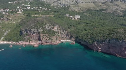 Drone flies above the coastline of the Adriatic sea, southern Montenegro, in a sunny summer day. Water in the sea is turquoise, clean and clear