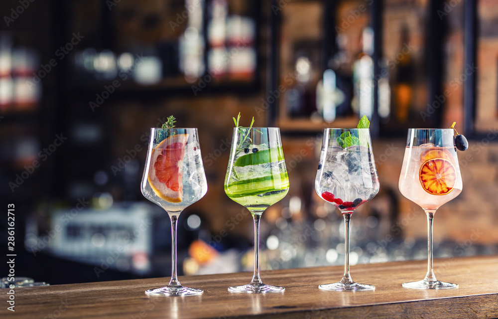 Wall mural Gin tonic cocktails in wine glasses on bar counter in pup or restaurant