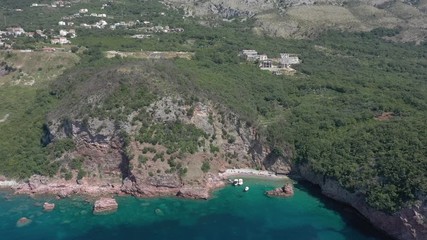 Drone flies above the coastline of the Adriatic sea, southern Montenegro, in a sunny summer day. Water in the sea is turquoise, clean and clear