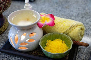 Towels with salft spa and candles for relax spa massage and body treatment. Thai herbal spa and wellness elements setting for traditional Thai massage, tropical spa treatment background concept.