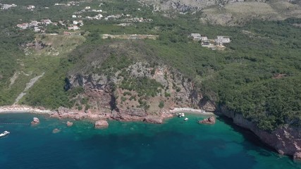 Drone flies above the coastline of the Adriatic sea, southern Montenegro, in a sunny summer day. Water in the sea is turquoise, clean and clear