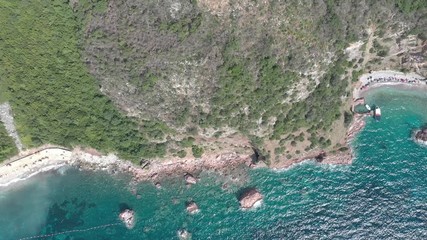 Drone flies above the coastline of the Adriatic sea, southern Montenegro, in a sunny summer day. Water in the sea is turquoise, clean and clear