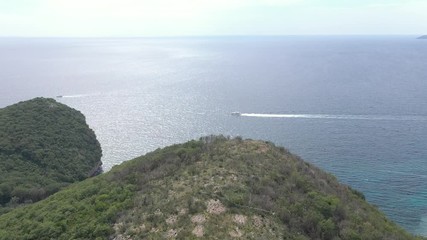 Drone flies above the coastline of the Adriatic sea, southern Montenegro, in a sunny summer day. Water in the sea is turquoise, clean and clear
