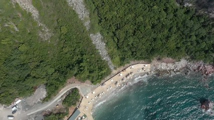 Drone flies above the coastline of the Adriatic sea, southern Montenegro, in a sunny summer day. Water in the sea is turquoise, clean and clear