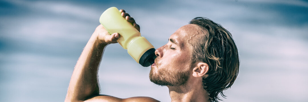 Athlete Drinking Water Bottle During Intense Training Workout Sweating In Summer Heat. Man Runner Dehydrated Hydrating With Thirst Quenching Hydration Sports Bottle Drink Panoramic Banner.