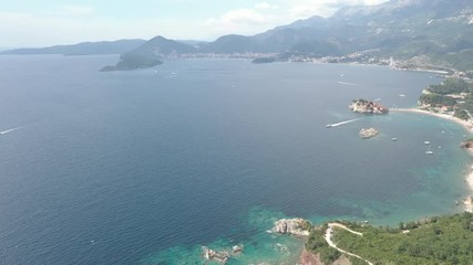 Drone flies above the coastline of the Adriatic sea, southern Montenegro, in a sunny summer day. Water in the sea is turquoise, clean and clear