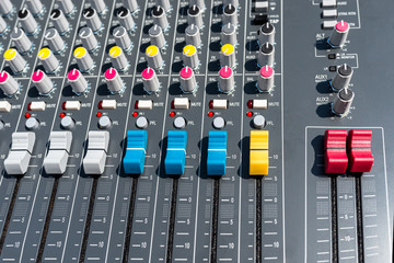 Close up photo of a professional sound mixer with many adjustments, knob switches and buttons of...