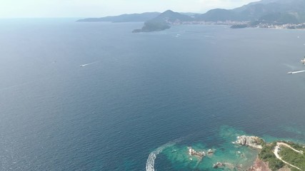 Drone flies above the coastline of the Adriatic sea, southern Montenegro, in a sunny summer day. Water in the sea is turquoise, clean and clear