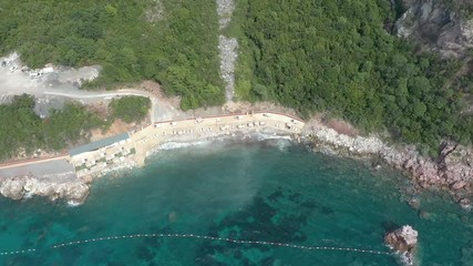 Drone flies above the coastline of the Adriatic sea, southern Montenegro, in a sunny summer day. Water in the sea is turquoise, clean and clear