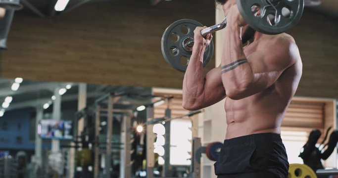 Handsome guy athletic man have workout day on his gym class lifting up the weights to development the biceps muscles