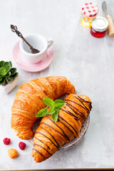Breakfast on white wooden background - croissant, jam, berries and coffee, flat lay