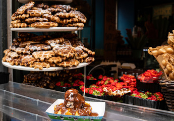 delicous waffle with ice cream and chocolate sauce with a colourful foody background