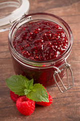 Jar of Raspberry Jam on a Rustic Wooden Table