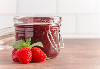 Jar of Raspberry Jam on a Rustic Wooden Table