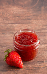 Jar of Classic Strawberry Jam on a Rustic Wooden Table