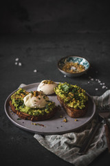 Fototapeta na wymiar Poached egg on top of the sourdough toast with smashed avocado and dukkah spice