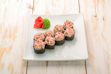 Japanese sushi roll topped with spicy salmon slice