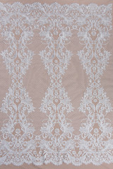 Texture lace fabric. lace on white background studio. thin fabric made of yarn or thread. a background image of ivory-colored lace cloth. White lace on beige background.