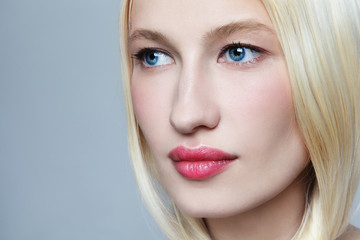 Close-up portrait of young beautiful blonde woman with clean makeup