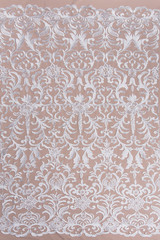 Texture lace fabric. lace on white background studio. thin fabric made of yarn or thread. a background image of ivory-colored lace cloth. White lace on beige background.