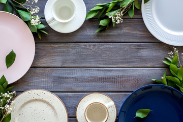 Empty plates and flowers frame for table setting on wooden background top view copyspace