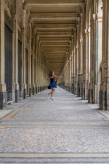 Blue dress girl in covered passage in the royal palace of Paris