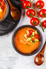 Traditional cold gazpacho tomato soup in black bowls on a gray background.