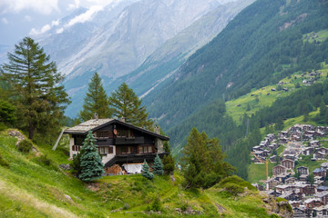 Fototapeta na wymiar Spectacular summer alpine landscape, mountain swiss wooden chalet with high mountains in background, Zermatt, Switzerland