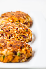 Vegan bean rice burgers cutlets on white dish.