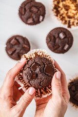 Chocolate vegan muffin in hand  on white background.