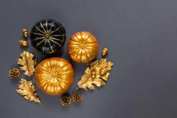 Autumn composition. Pumpkins, gold color dried leaves on background. Autumn, fall, halloween concept. Flat lay, top view, copy space